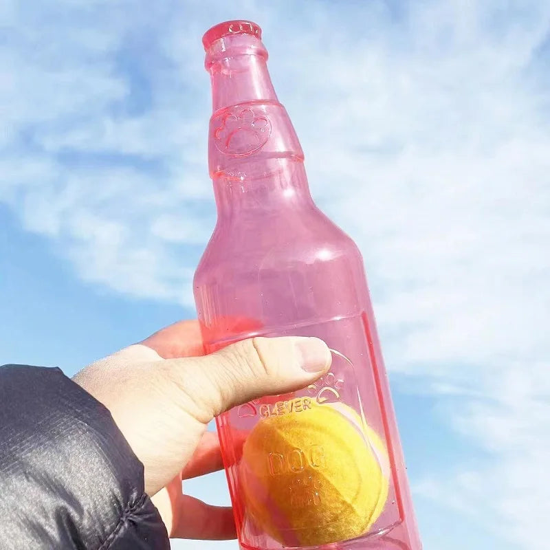 Red bottle-shaped dog toy with a tennis ball inside